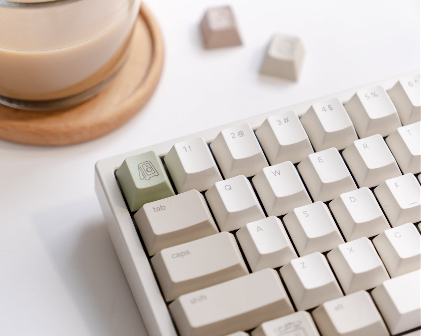 the standard cafe keycaps, focused on a spring green novelty key, on a starlit white nemui keyboard.