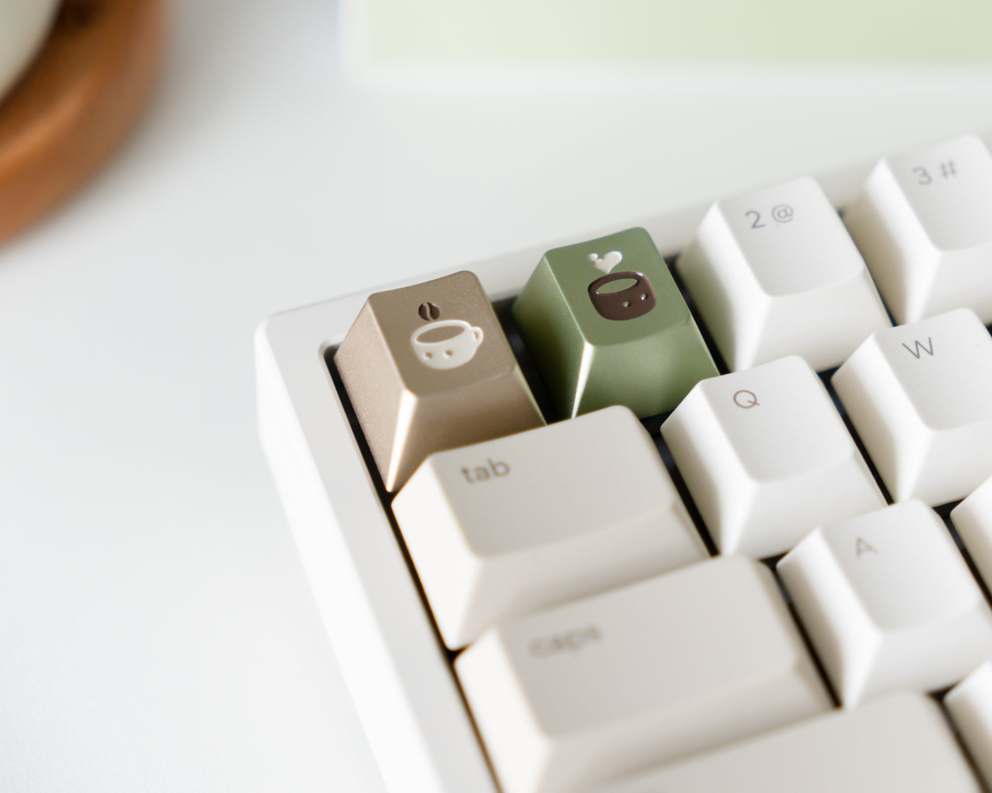 metal keycaps in cherry profile with coffee and tea designs engraved on top.
