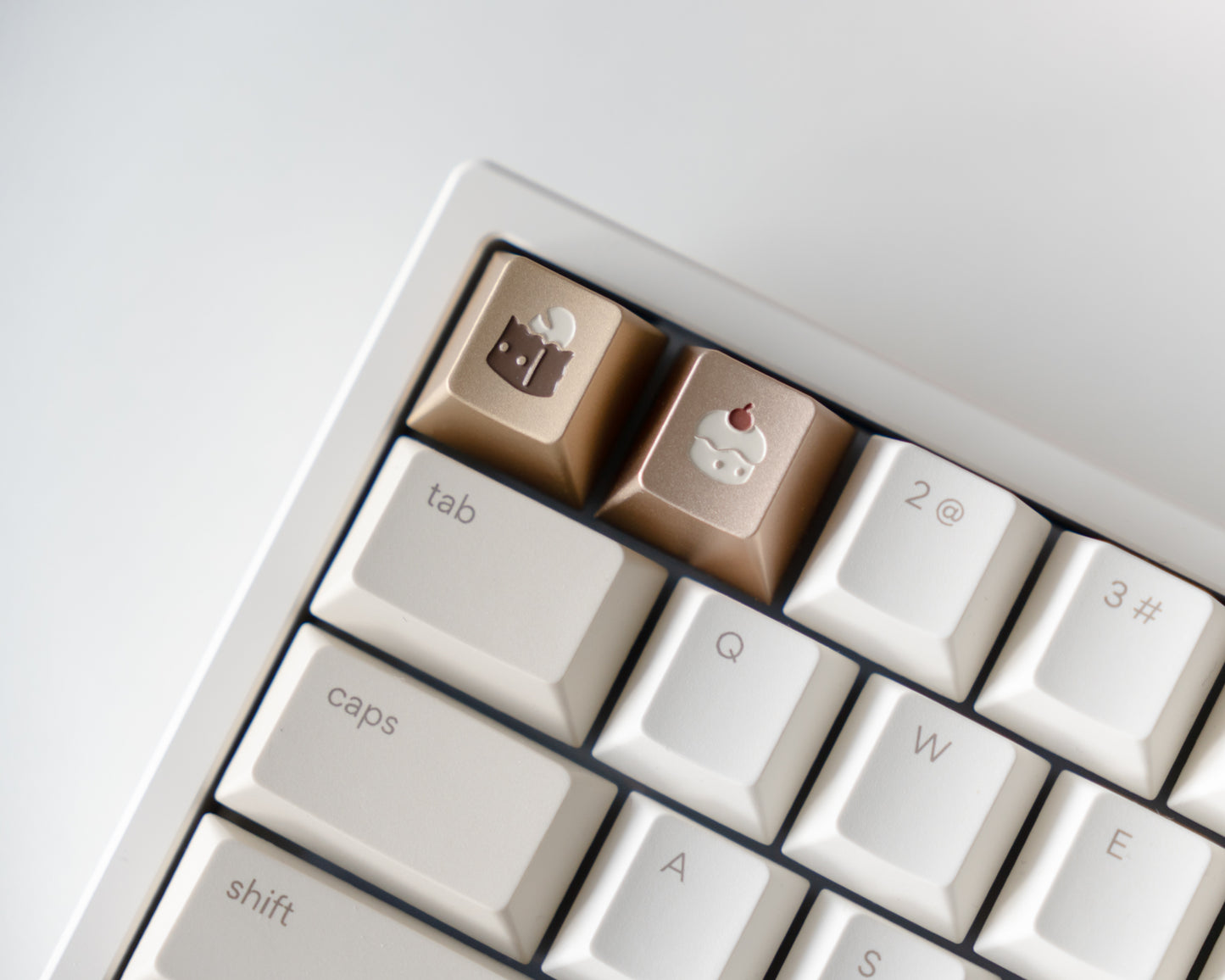 metal keycaps in cherry profile with bread and cupcake designs engraved on top.
