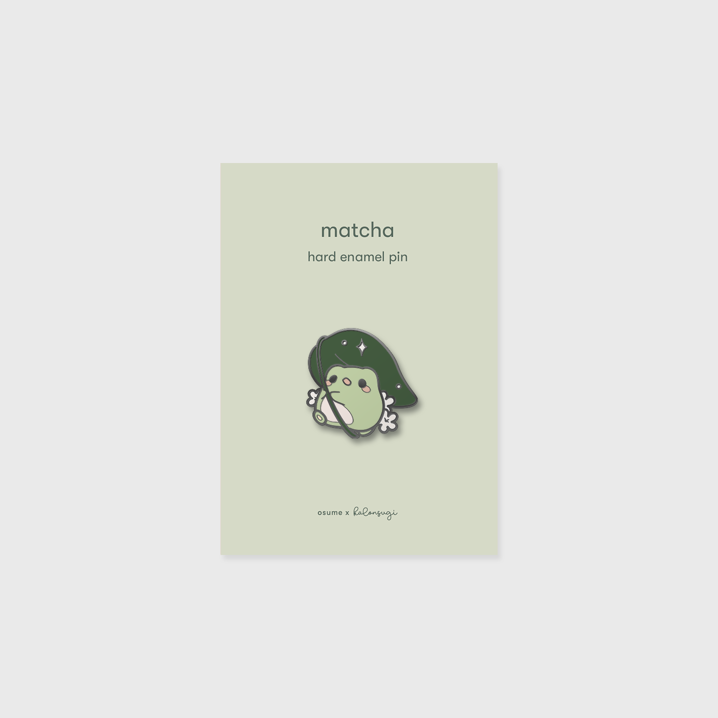 osume's matcha enamel pin featuring a cute frog with a leaf umbrella.