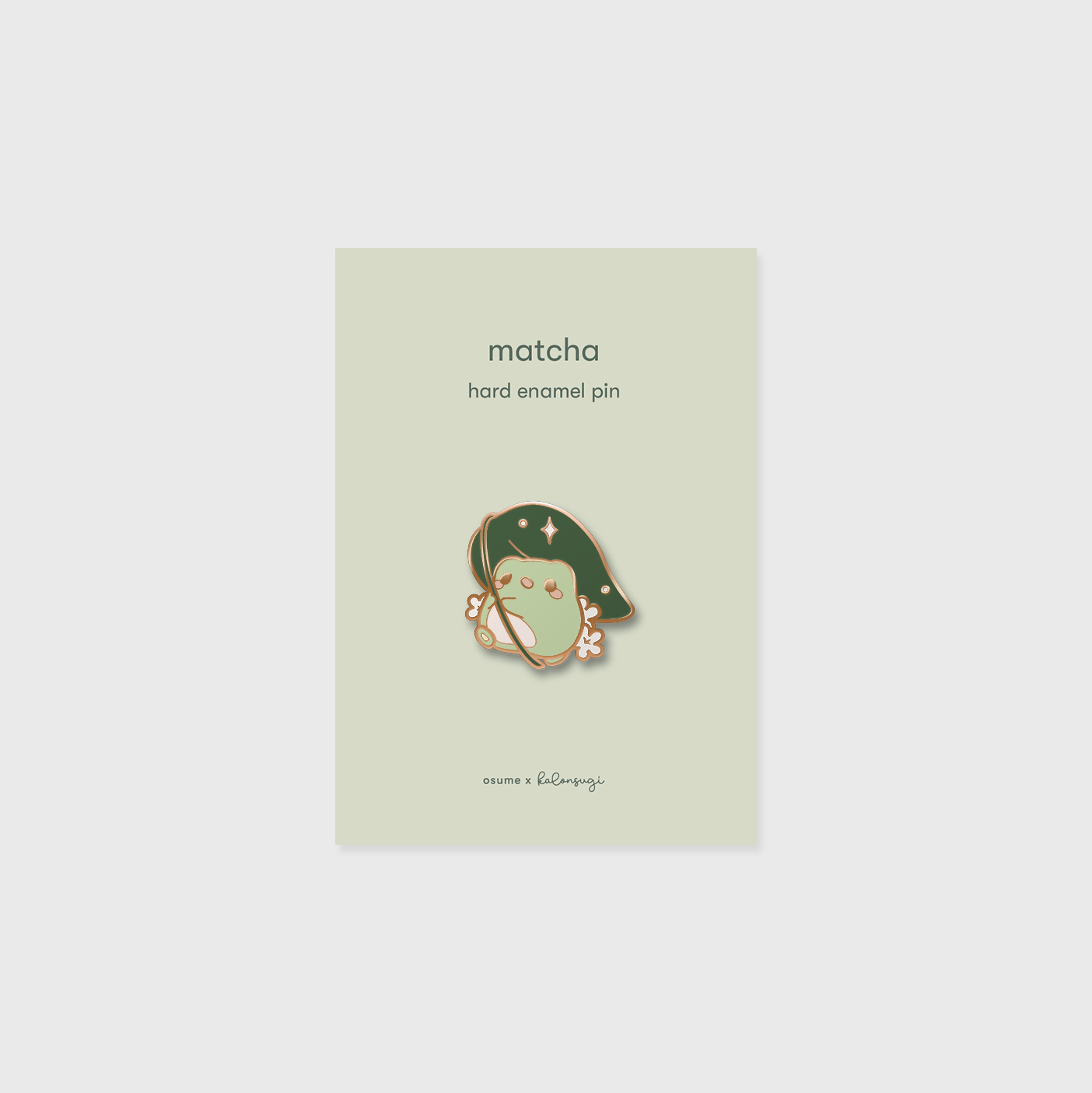 osume's matcha enamel pin in rose gold featuring a cute frog with a leaf umbrella.