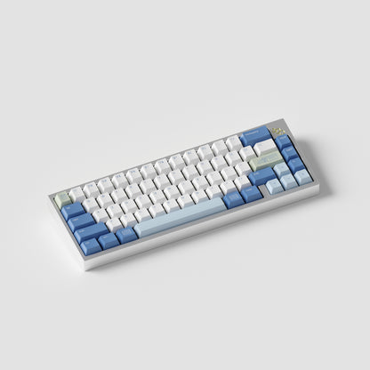 the standard konbini green keycaps, with novelty keys, on a silver 65% keyboard.