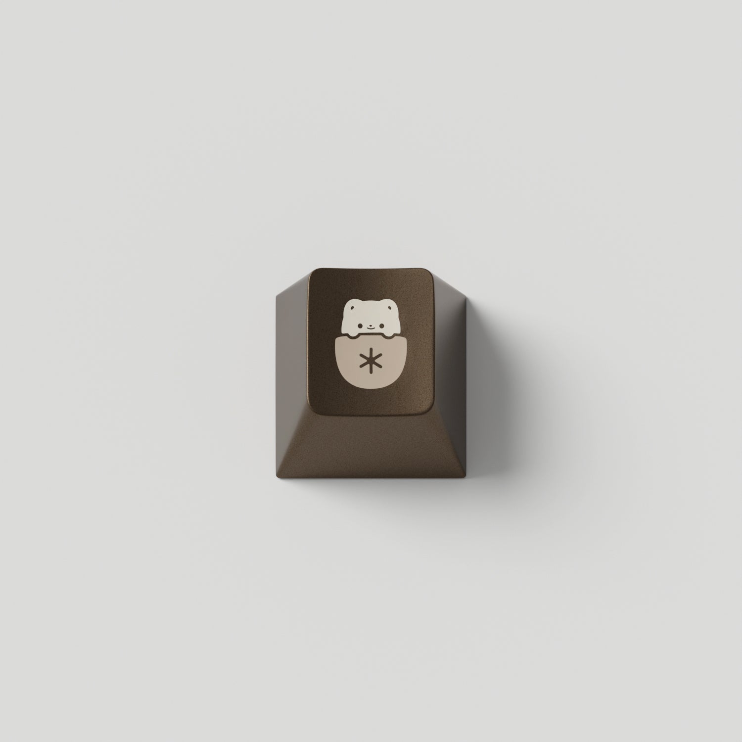 a brown metal keycap in cherry profile with a mocha cat design engraved on top.